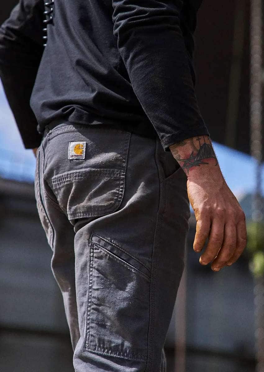 A person wearing Carhartt work pants looking out over a job site