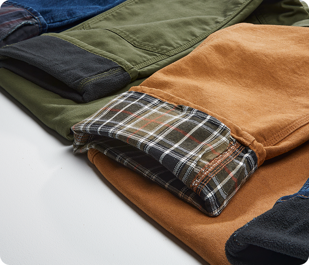 Several pairs of lined Carhartt pants cuffed to show the lining