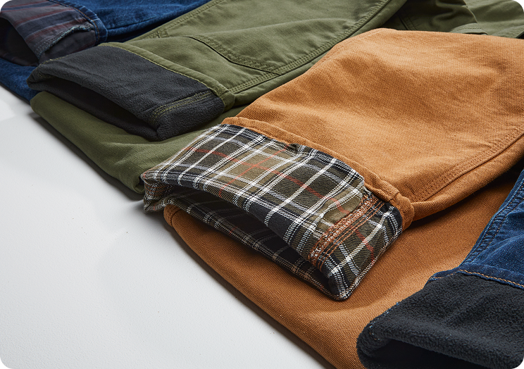Several pairs of lined Carhartt pants cuffed to show the lining