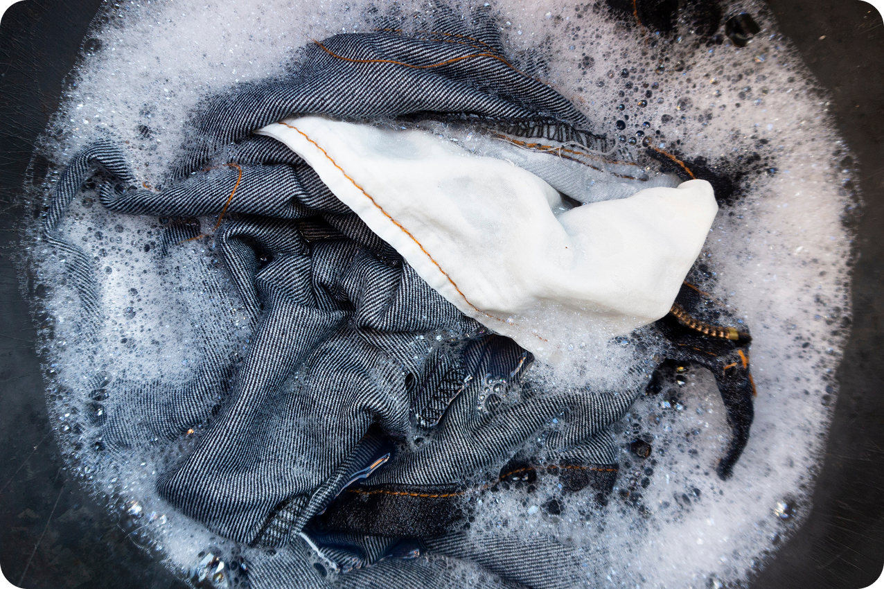 Carhartt jeans in a washing machine with water and soap suds