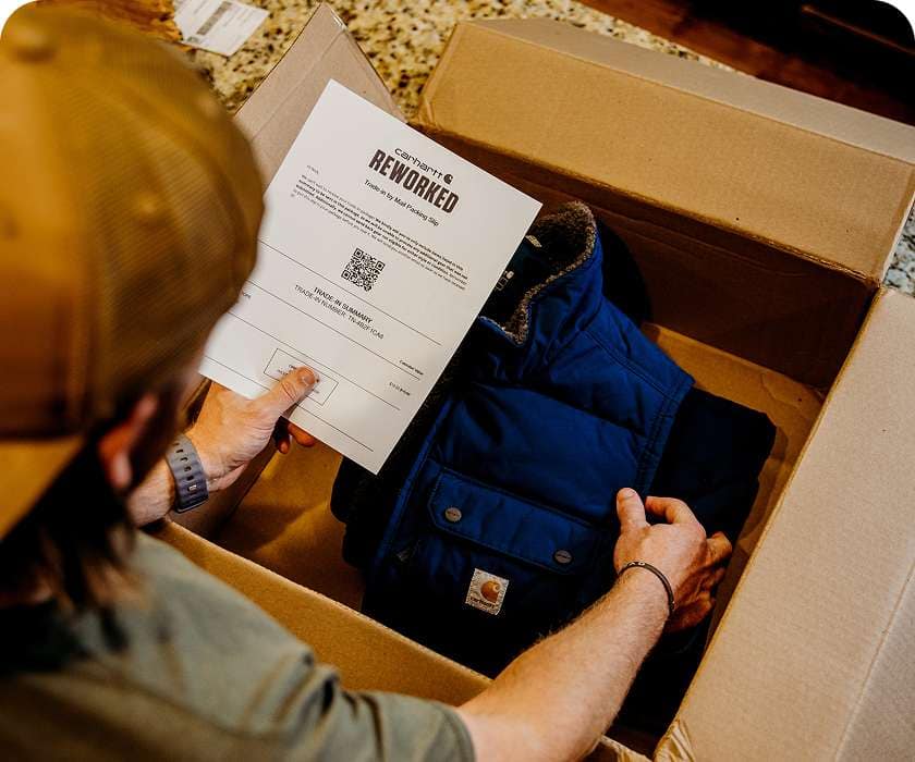 Nick packing his gear into a box while holding the packing slip.