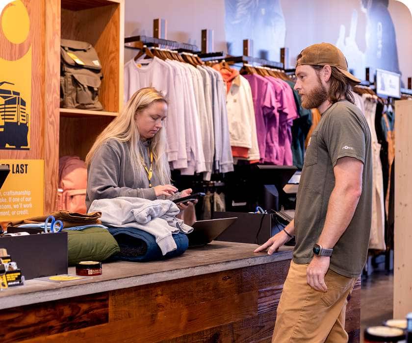 Nick waiting while a Carhartt associate reviews his trade at a sale counter in store.